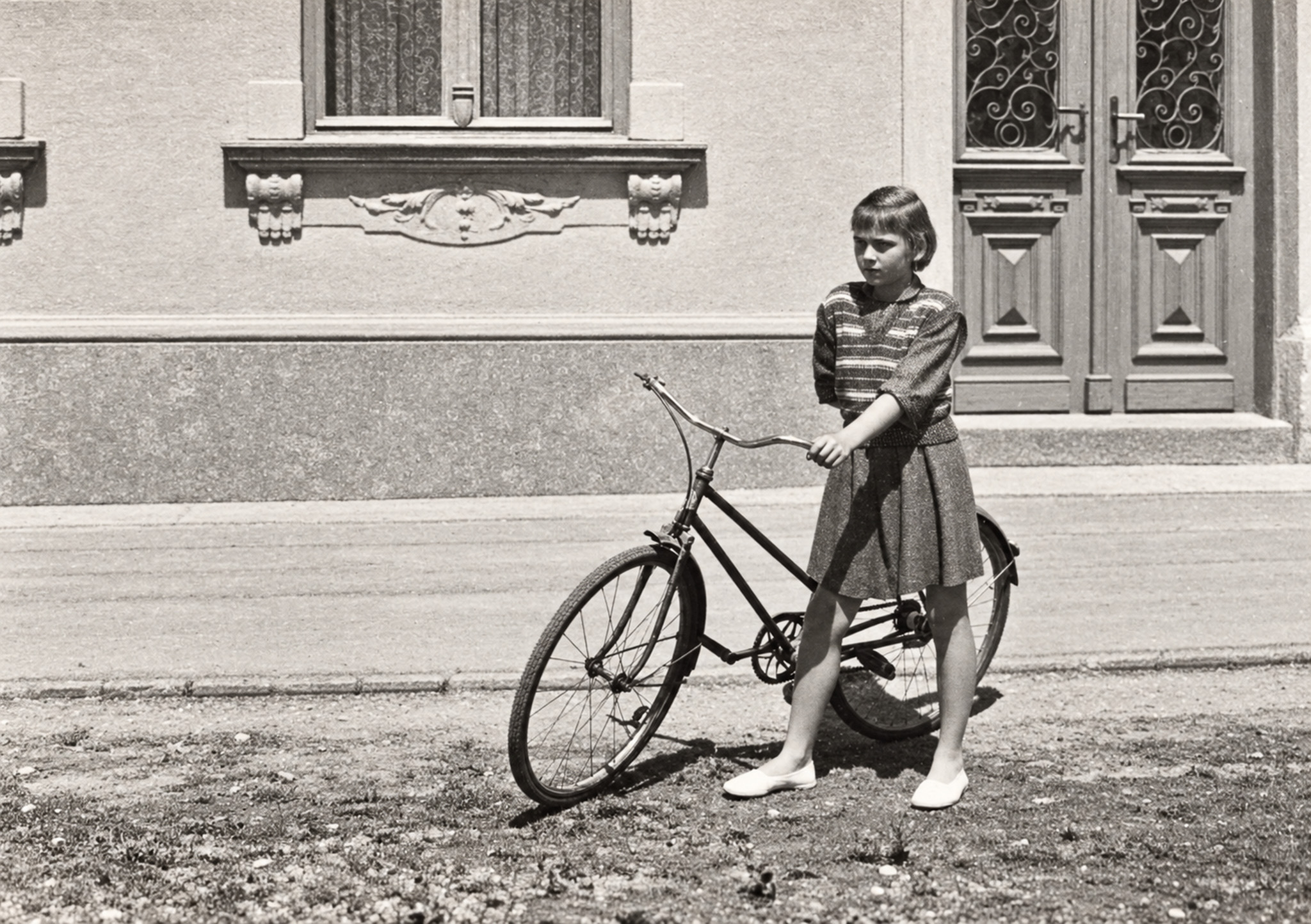 Sestra Anička pred naším domom. Dodnes je vášnivou cyklistkou.